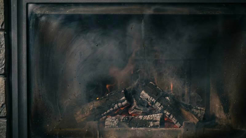Копоть и сажа на стекле камина при тлении дров
