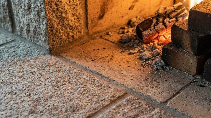 Крупный план каменной кладки камина с тлеющими углями